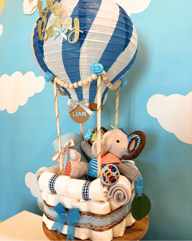 Baby shower gift with hot air balloon design, stuffed animals, and baby items.